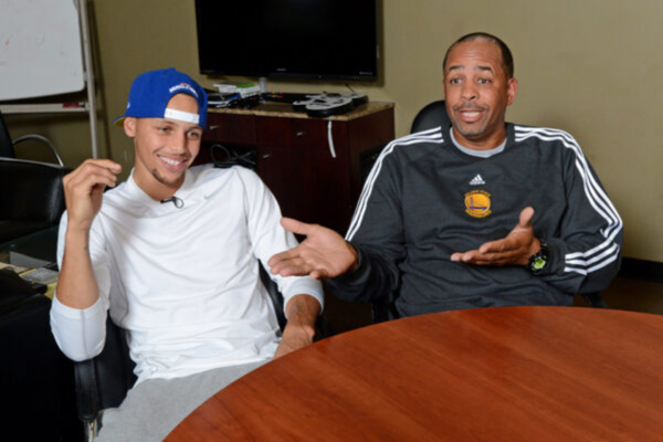 Golden State Warriors player Stephen Curry, left, listens to his father Dell Curry, a former National Basketball Association (NBA) player, as he talks about having a son playing in the NBA during an interview in the Golden State Warriors training facility