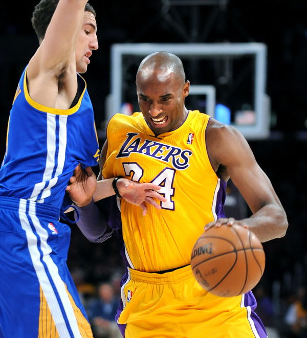 Lakers Kobe Bryant drives past Warriors Klay Thompson in the 1st quarter at the Staples Center Frid