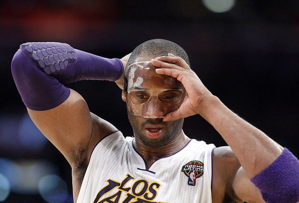 Lakers guard Kobe Bryant adjusts his protective mask before the start of the second half against th