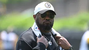 Mike Tomlin wearing a cap and shades with a towel hung around his neck