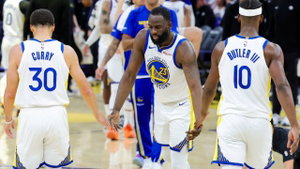 Draymond Green shaking hands with Stephen Curry and Jimmy Butler, as they head to the bench