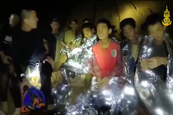 Members of the Royal Thai Navy are pictured with the 12 schoolboys members of a local soccer team