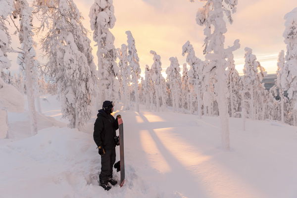 Young man with snowboard standing in snow-covered landscape model released, Symbolfoto, LHPF01528