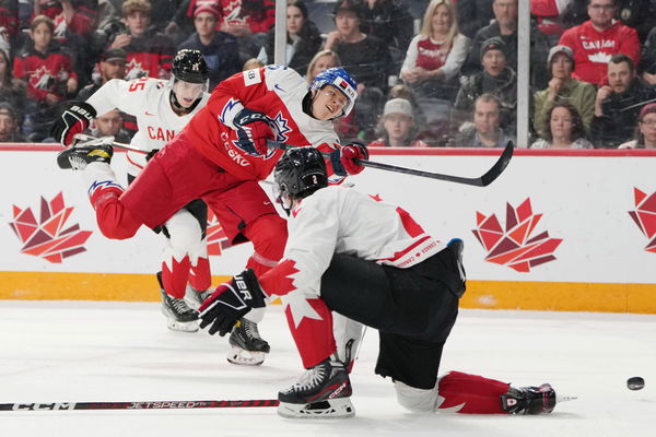 December 26, 2022, Halifax, NS, Canada: Czechia s Jakub Kos, centre, shoots between Canada s Kevin Korchinski, left, and