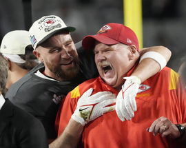 Travis KelAndy Reid celebrates on the podium with tight end Travis Kelce