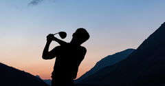 Composition of silhouette of male golf player over landscape and blue sky with copy space. sport and competition concept