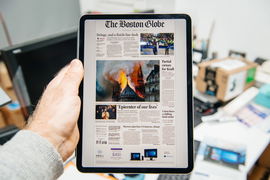 Paris, France – Apr 15, 2019: Man reading on Boston Globe iPad Pro Apple News Plus digital newspaper