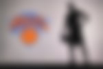 NEW YORK, USA, JUN 18, 2020: New York Knicks logo of professional basketball club in american league. Silhouette of basket player in foreground. Sport concept photo, edit space.