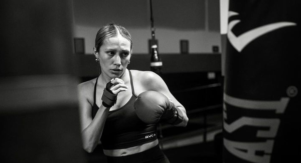 Woman boxer in athletic attire and gloves, showcasing her punch