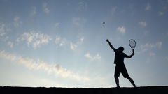Silhouette of man playing tennis